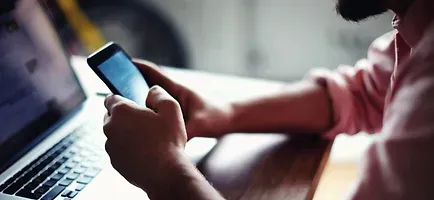 Person using phone and laptop